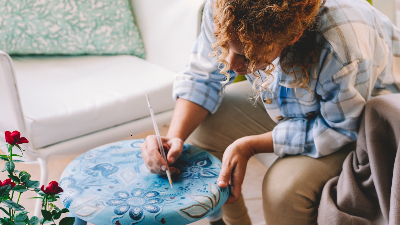 Adult woman painting outdoors with joy and concentration.